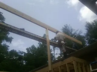 Carpenter setting a ridge beam over a new addition frame — Ice Dam Removal by Roofing Brothers in Chappells