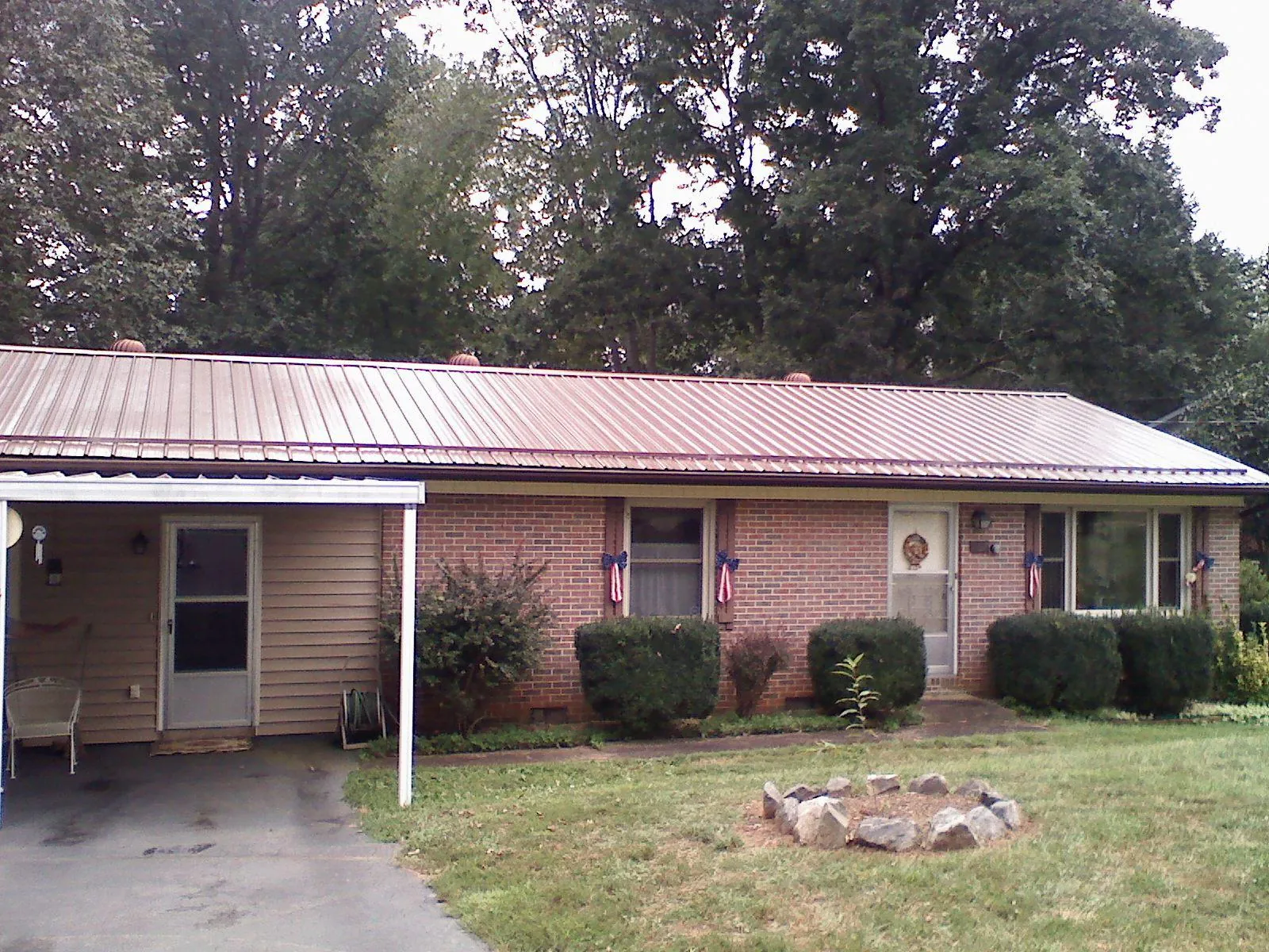 Bronze metal roof and carport on a brick ranch home — Roof Repair work by our crew in Chappells