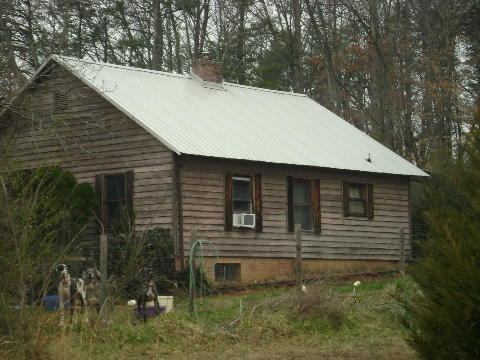 White metal roof on an old wood sided farmhouse, from a Metal Roof Installation job in Chappells